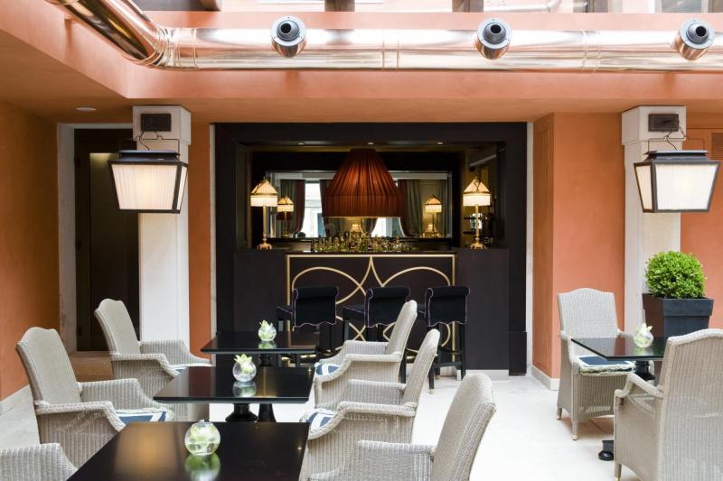 Breakfast area at Splendid Venice has a bar and high top chairs, two seater tables and an elegant interior design