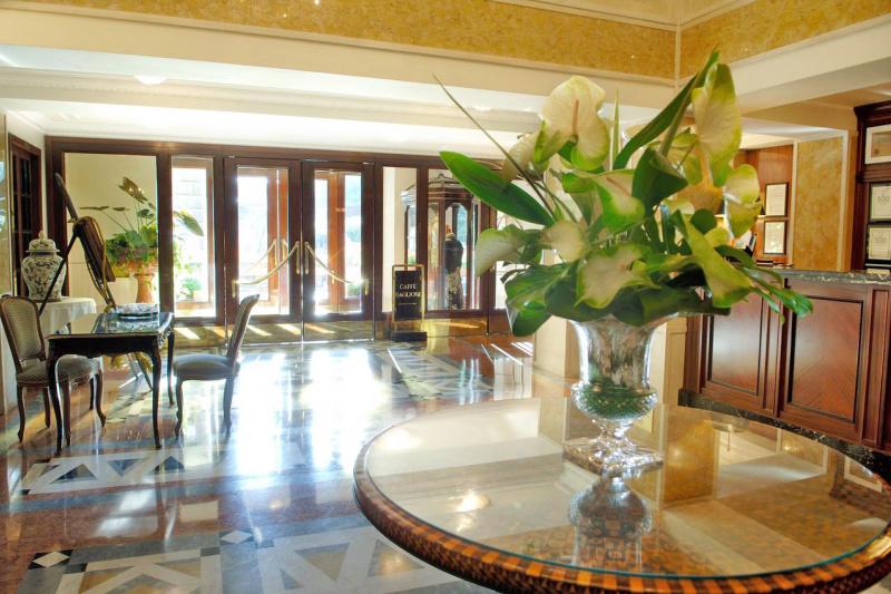 The spacious lobby has a check-in desk, concierge desk, and decorative flower centerpiece