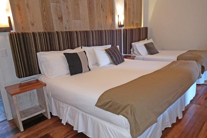 Triple room with a double bed, a single bed and extra room next to the beds.