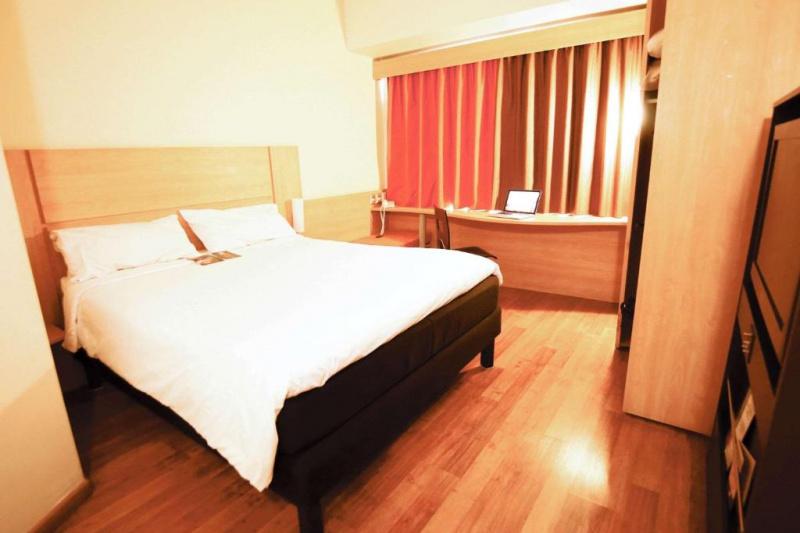 The standard double room, with smooth floors, a double bed and large windows.