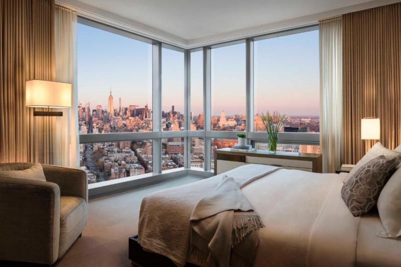 Guestroom with floor-to-ceiling windows and city views