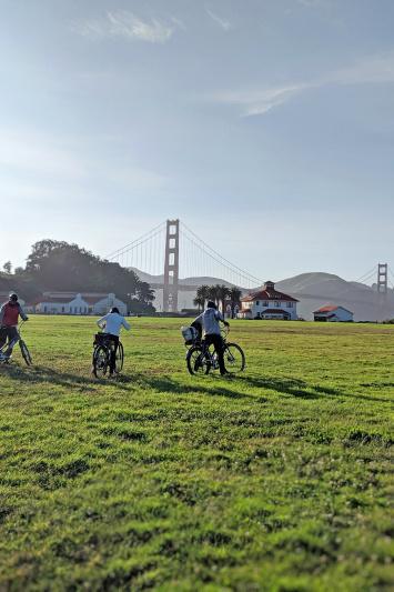 Travelers use bikes to explore Crissy Feilds near the Golden Gate Bridge