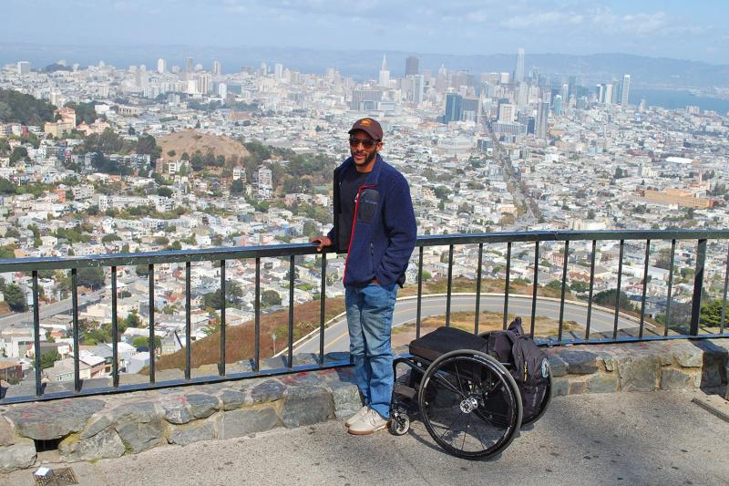 Wheel the World travelers stands at Twin Peaks view point and admires city