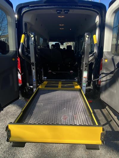 Accessible black van with wheelchair lift platform